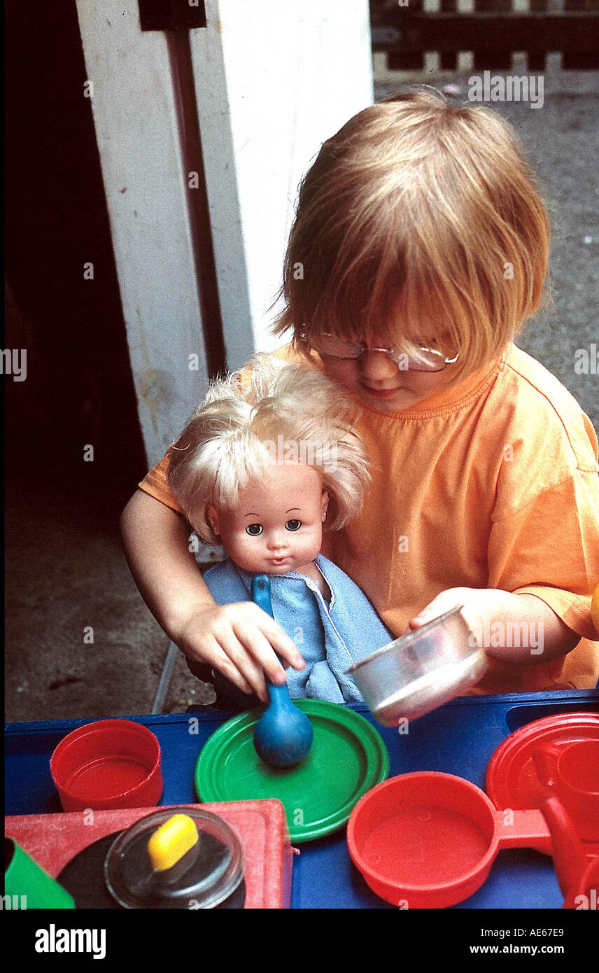 Nursery school girl playing with doll Stock Photo - Alamy