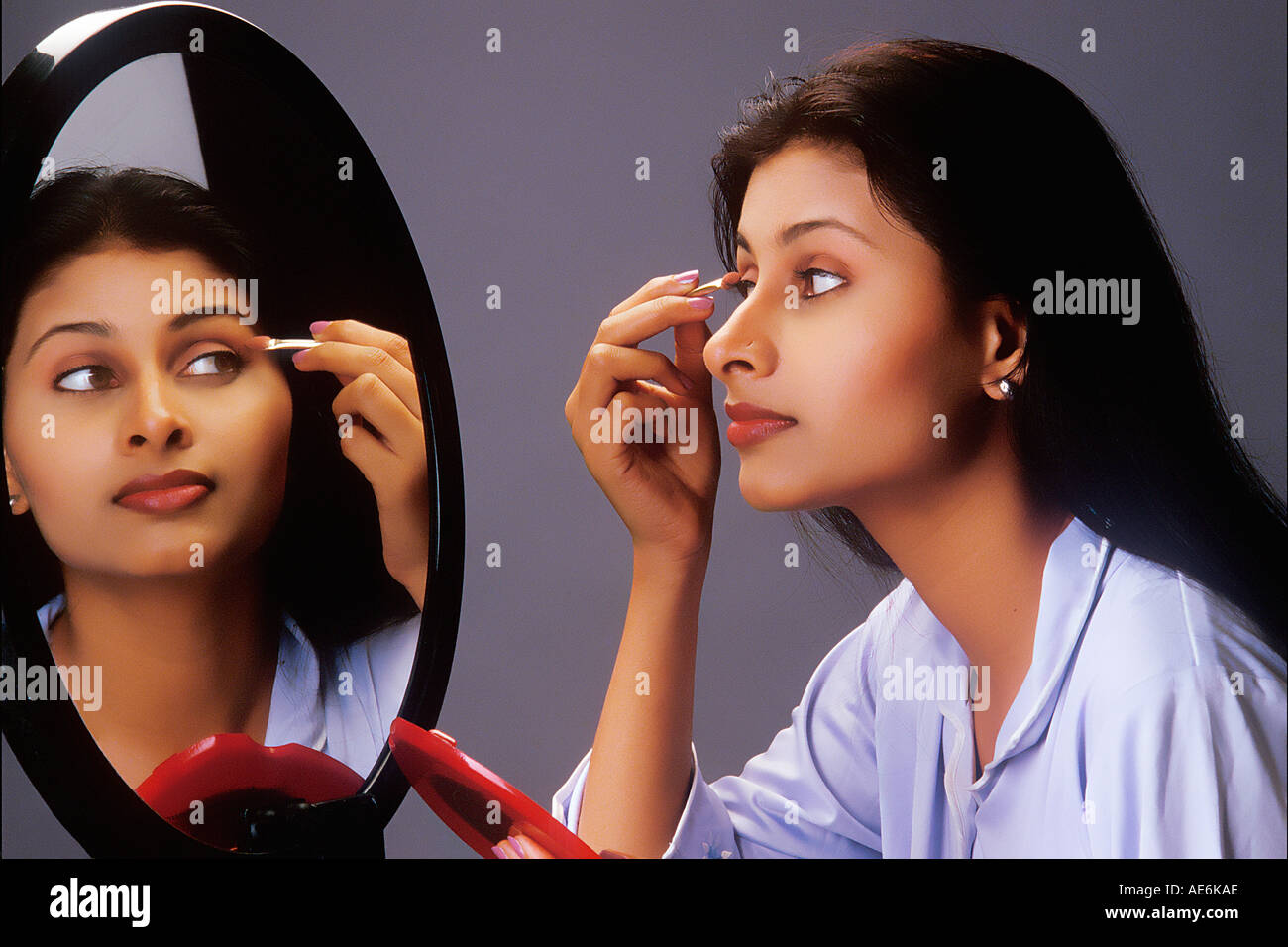 RHS70998 South Asian Indian Girl applying makeup in front of a mirror Model Release Number 442 Stock Photo