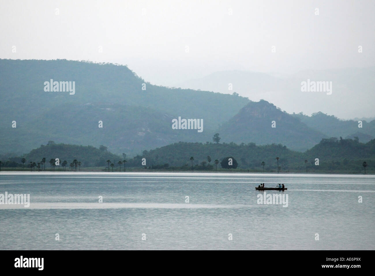 Lake with fishing boat kayak canoe with hills in background Stock Photo