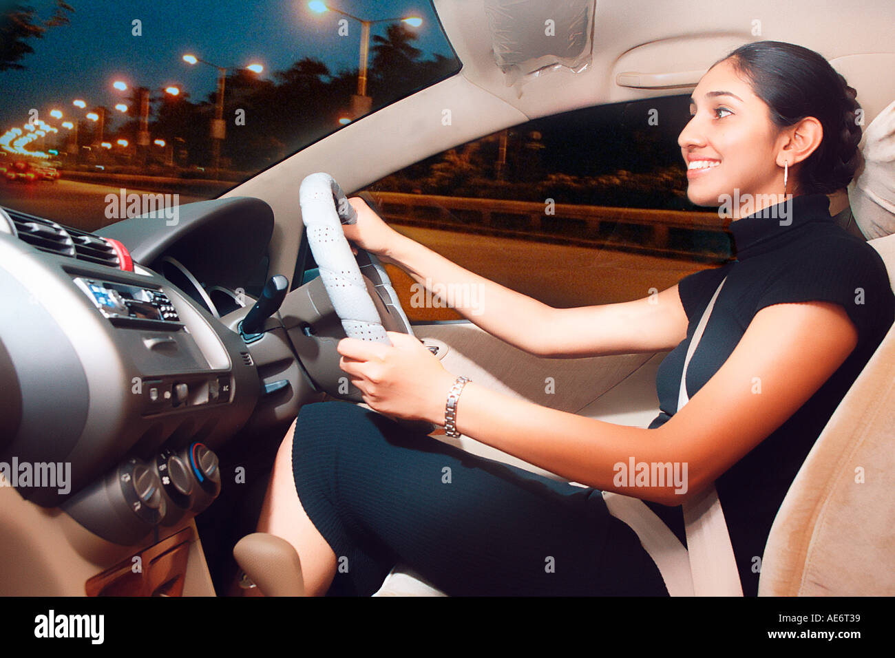 RHS70956 South Asian Indian young happy  executive lady driving modern car in India Model Release Number 522 Stock Photo