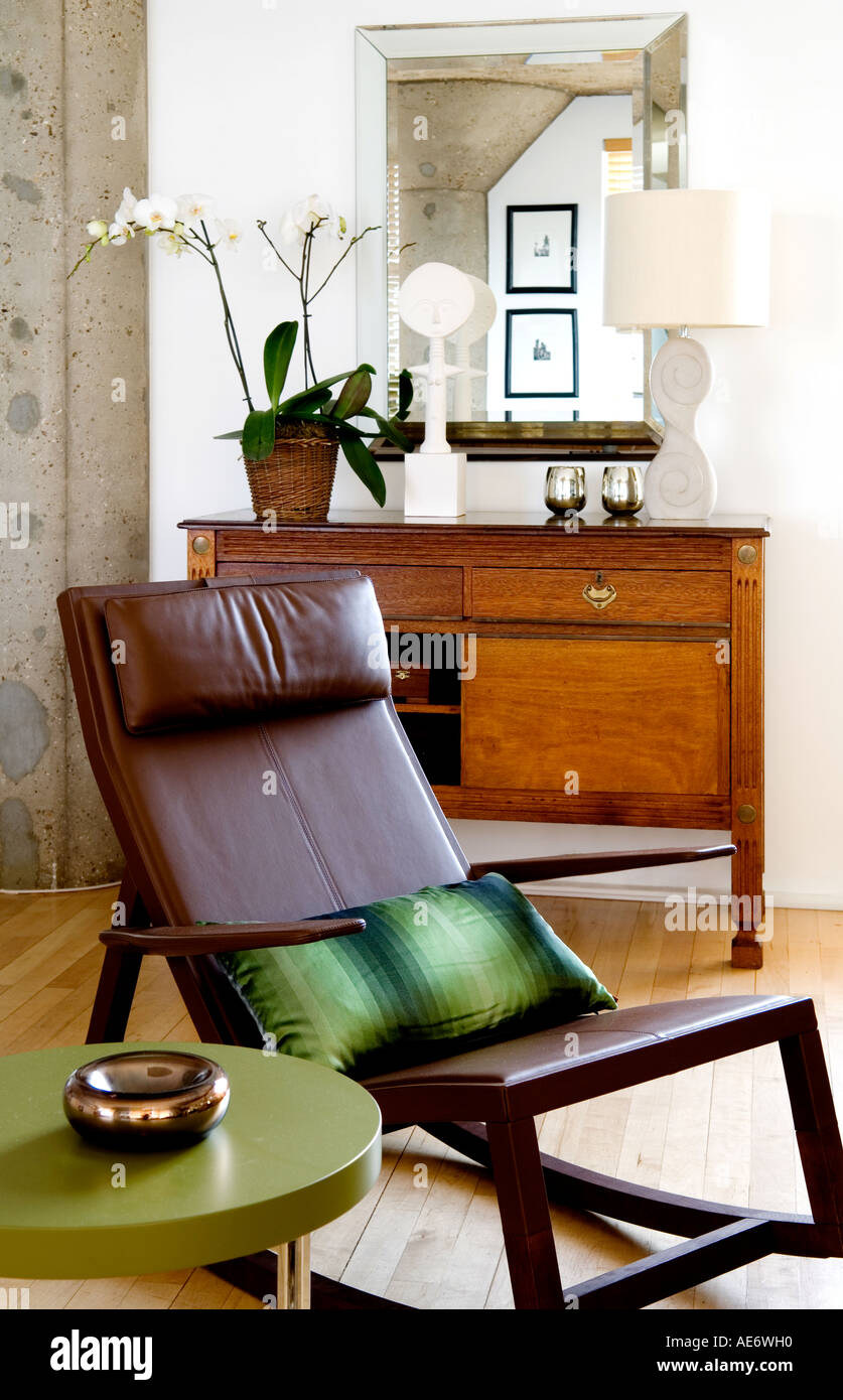 Poltrona Frau rocking chair beside round green side table Stock Photo
