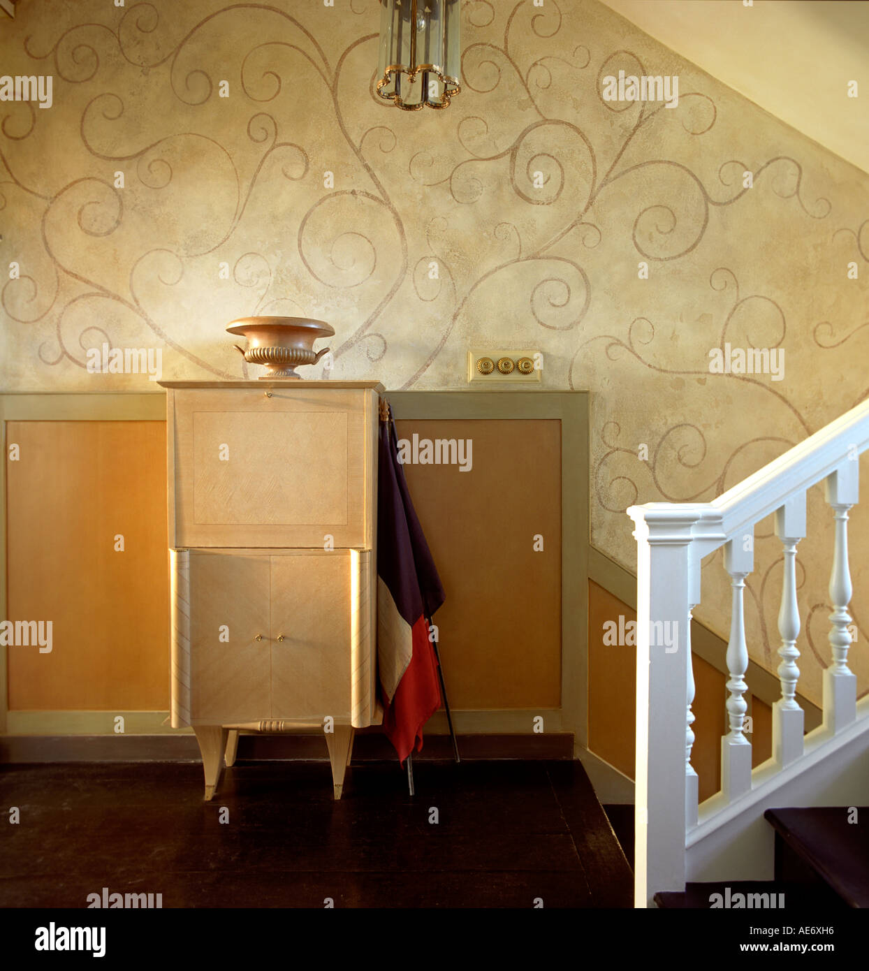 Stair landing with and swirly wallpaper in a