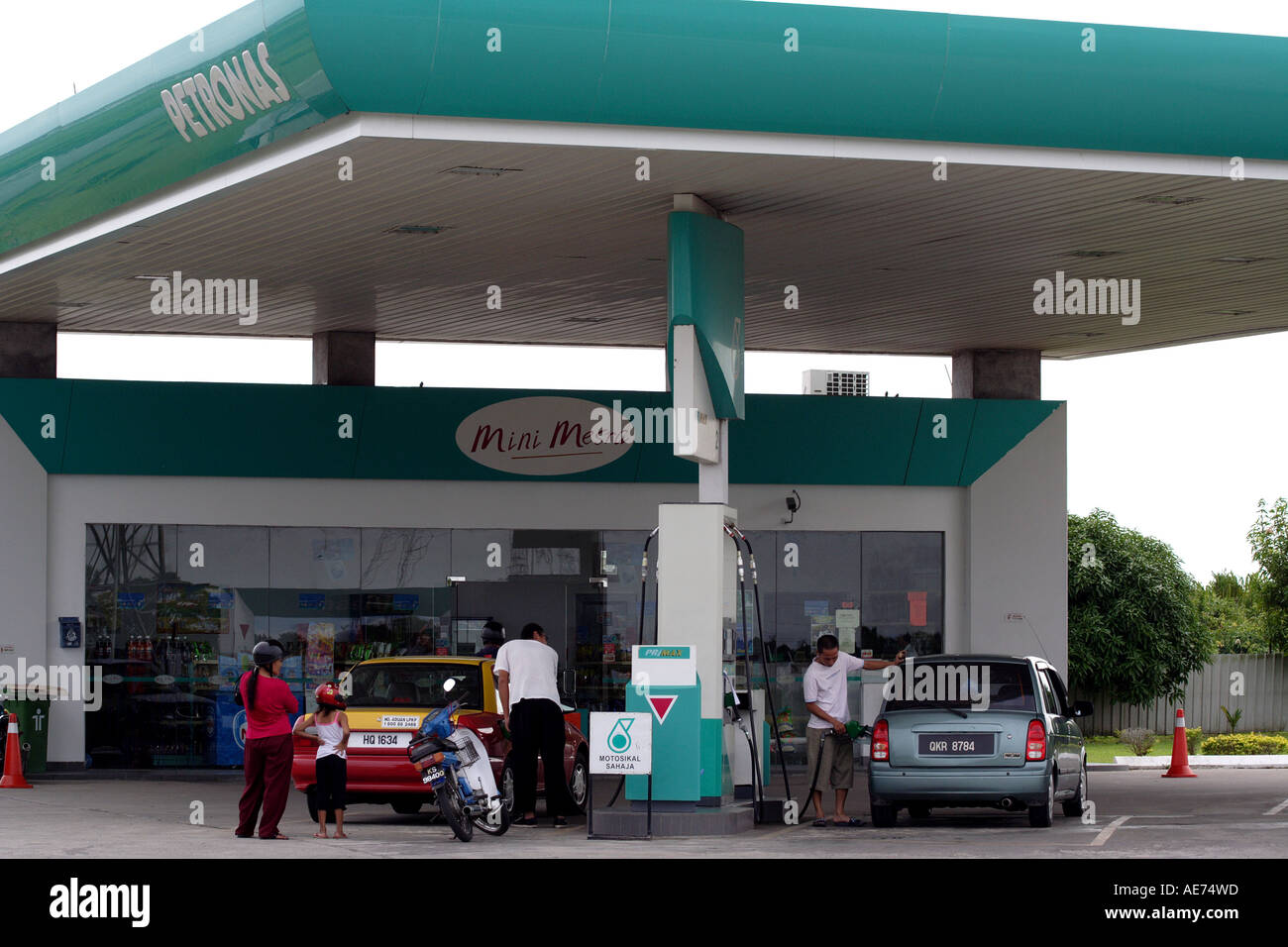 Gas Station Attendant Filling a Taxi With Fuel in Kuching, Sarawak