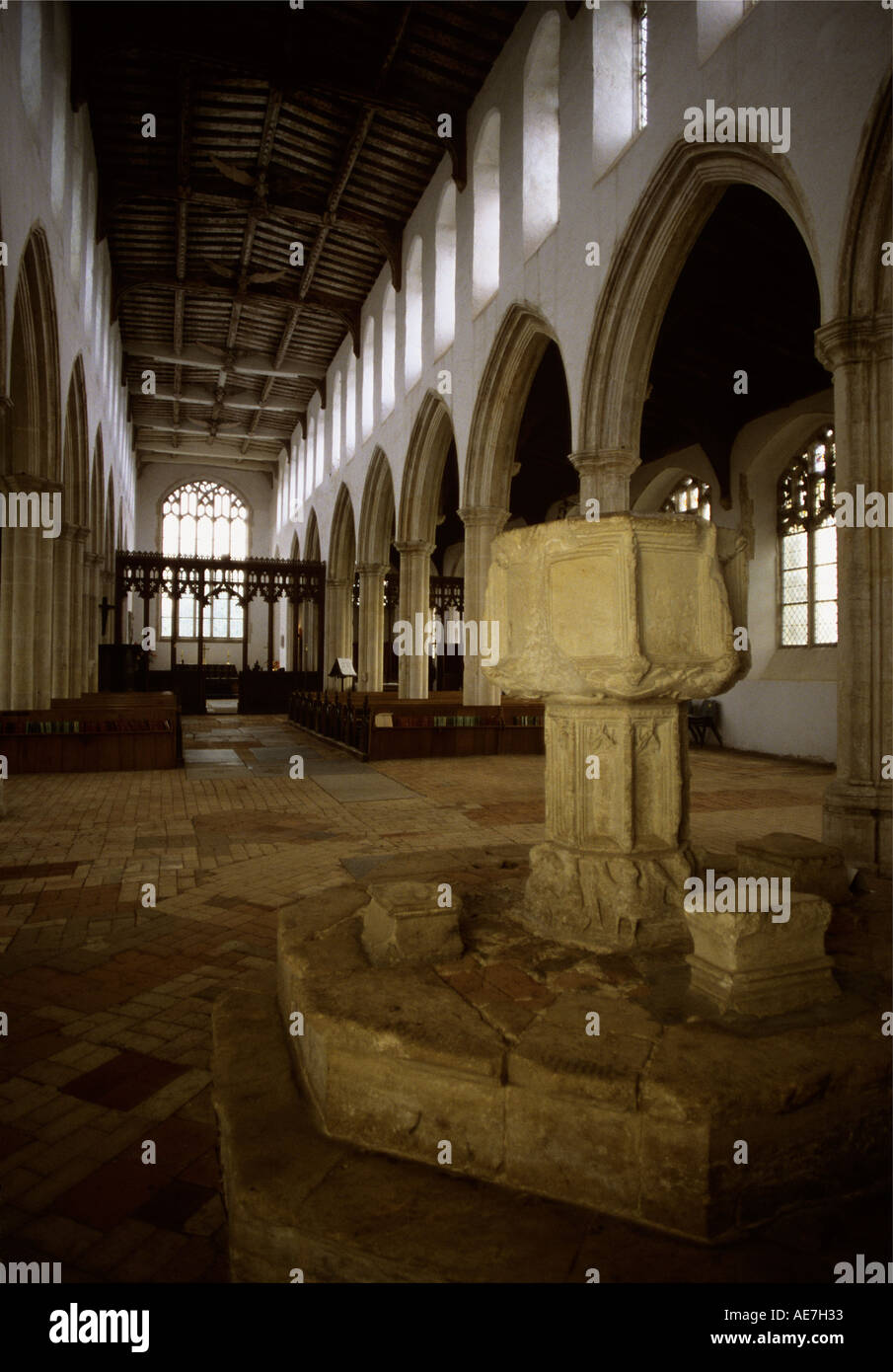 15th century Font surrounded by complex brick floor The tie Beam roof covers a nave of 127 feet Suffolk Stock Photo