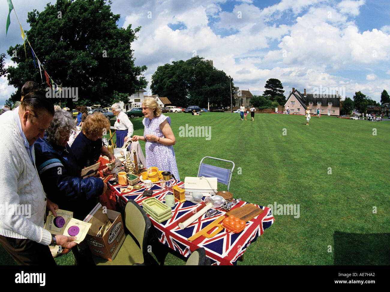 Village fete on the green tables with old records and assorted treasures table covered with union Jacks Suffolk Stock Photo
