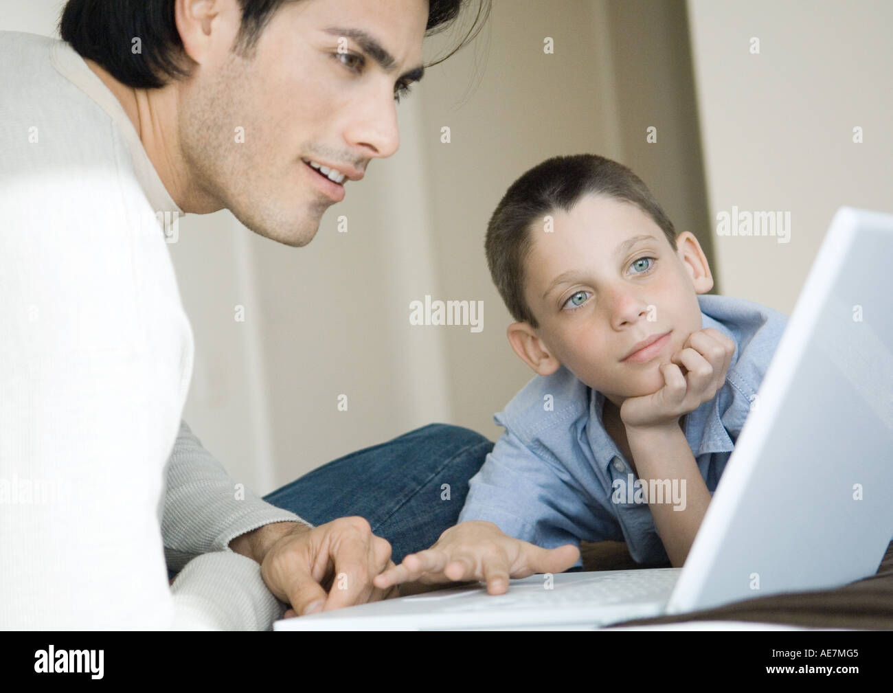Man and boy using laptop together Stock Photo