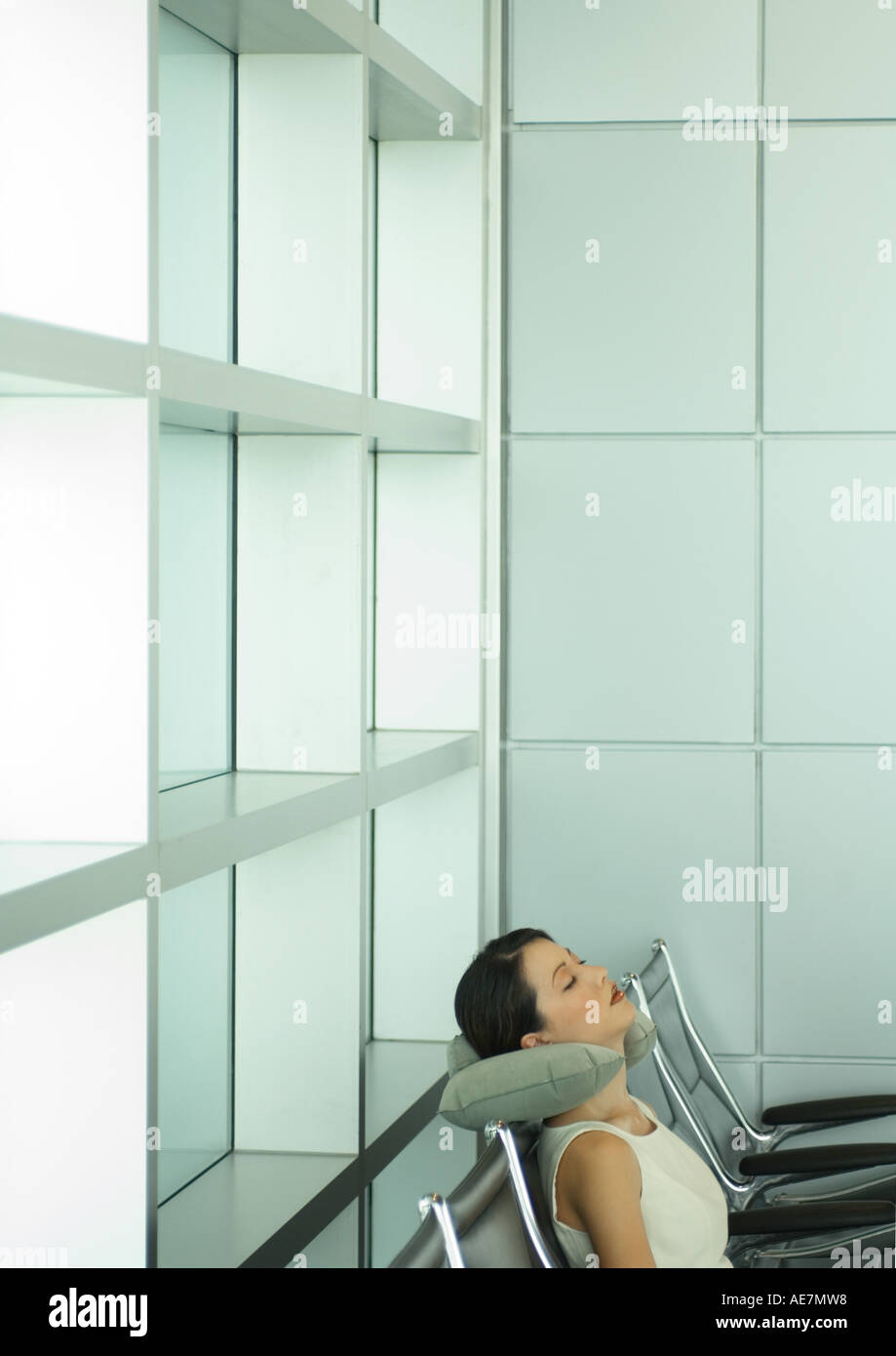 Woman sleeping in airport lounge, using neck cushion Stock Photo Alamy
