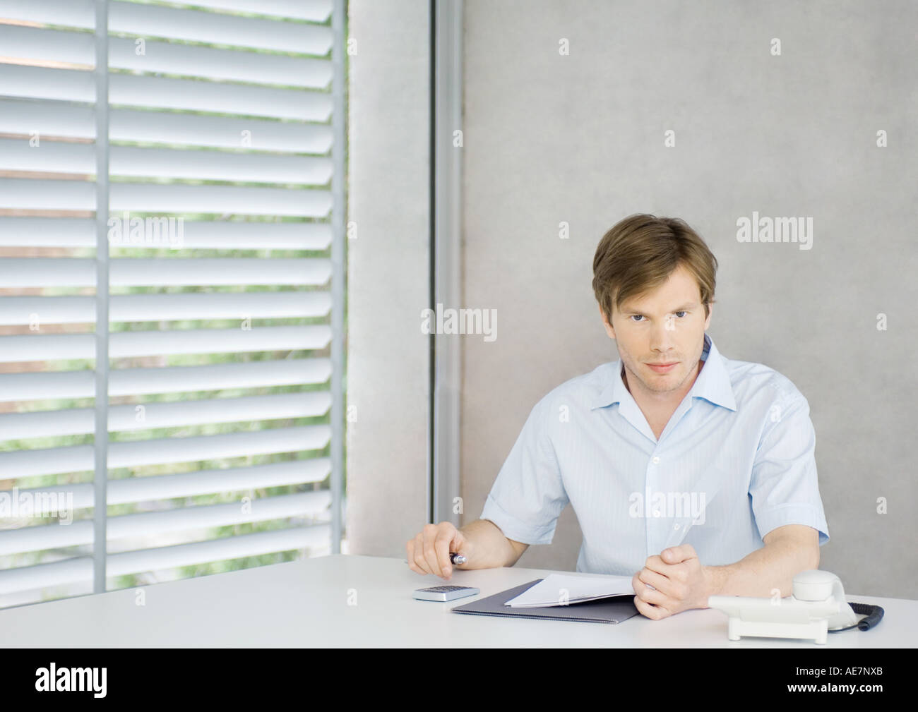 Young man sitting at desk Stock Photo
