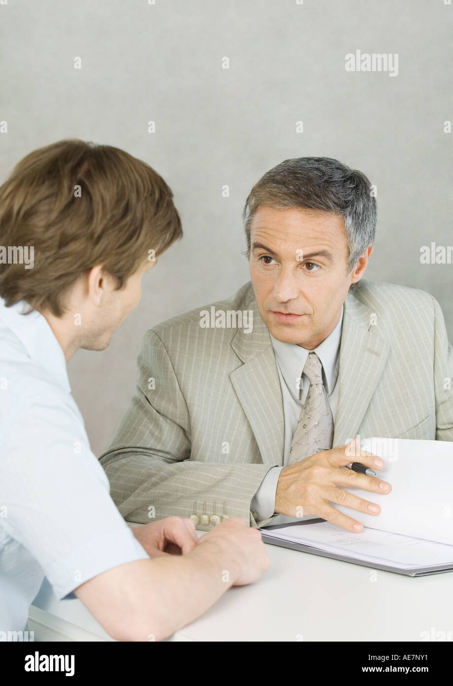 Young man with mature businessman, discussing document Stock Photo