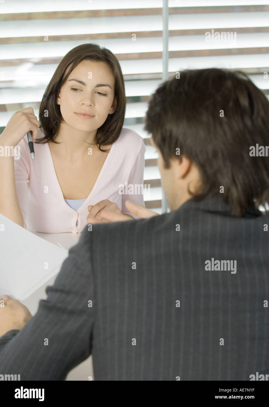 Woman sitting across from businessman Stock Photo