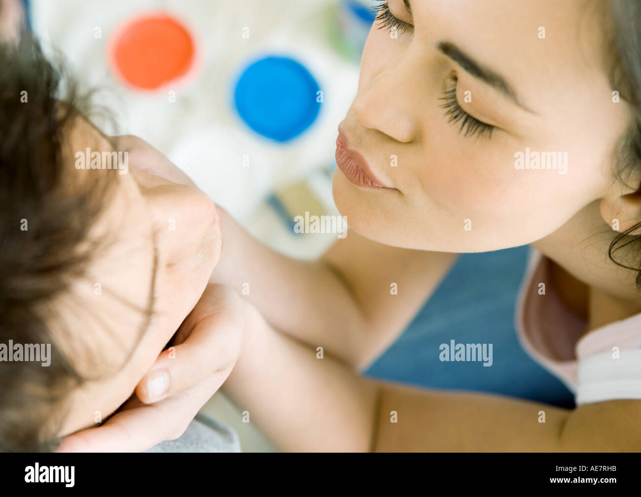 Woman holding man's face and puckering lips for a kiss, high angle view Stock Photo
