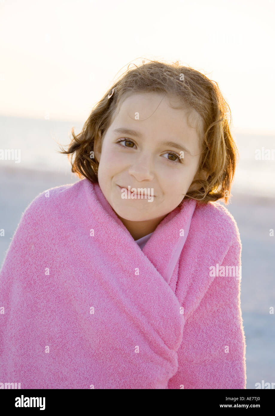 Girl wrapped in towel on beach, portrait Stock Photo Alamy