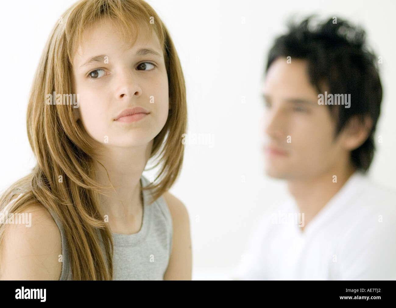 Preteen girl looking away, older brother in background Stock Photo