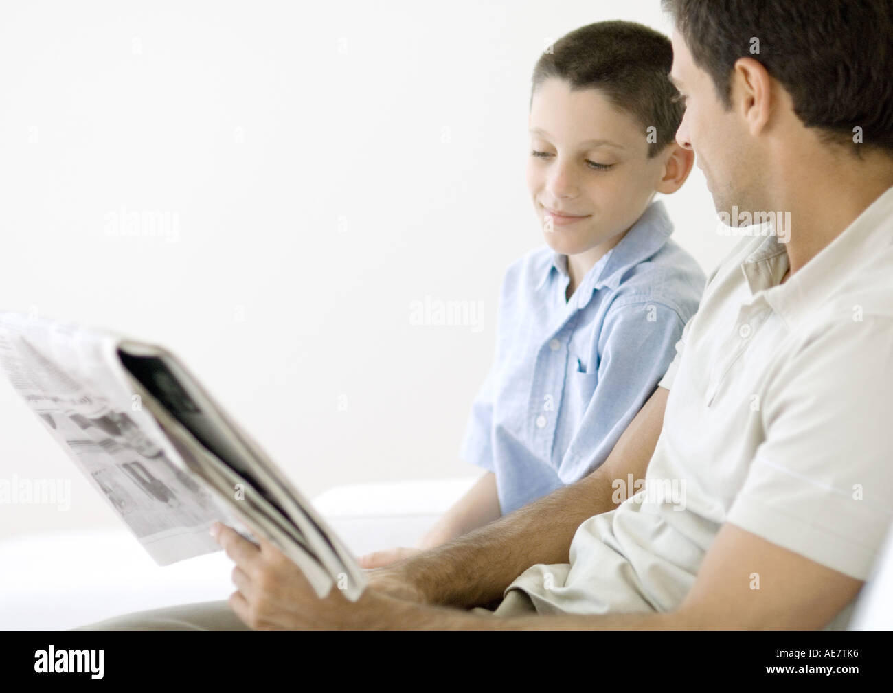 Man and son looking at newspaper together Stock Photo