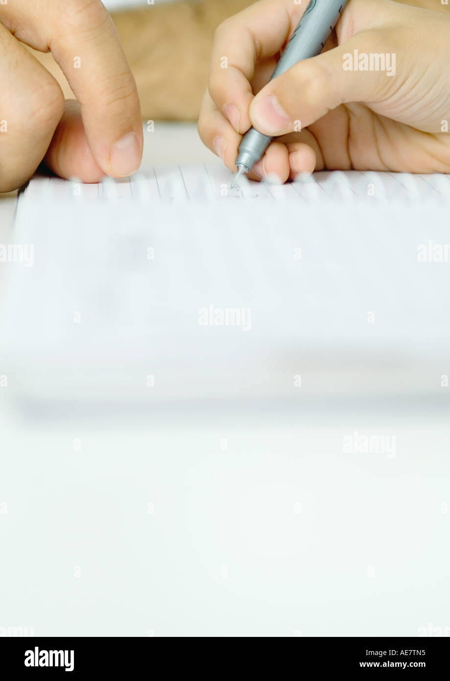 Boy doing homework with father's help, cropped Stock Photo