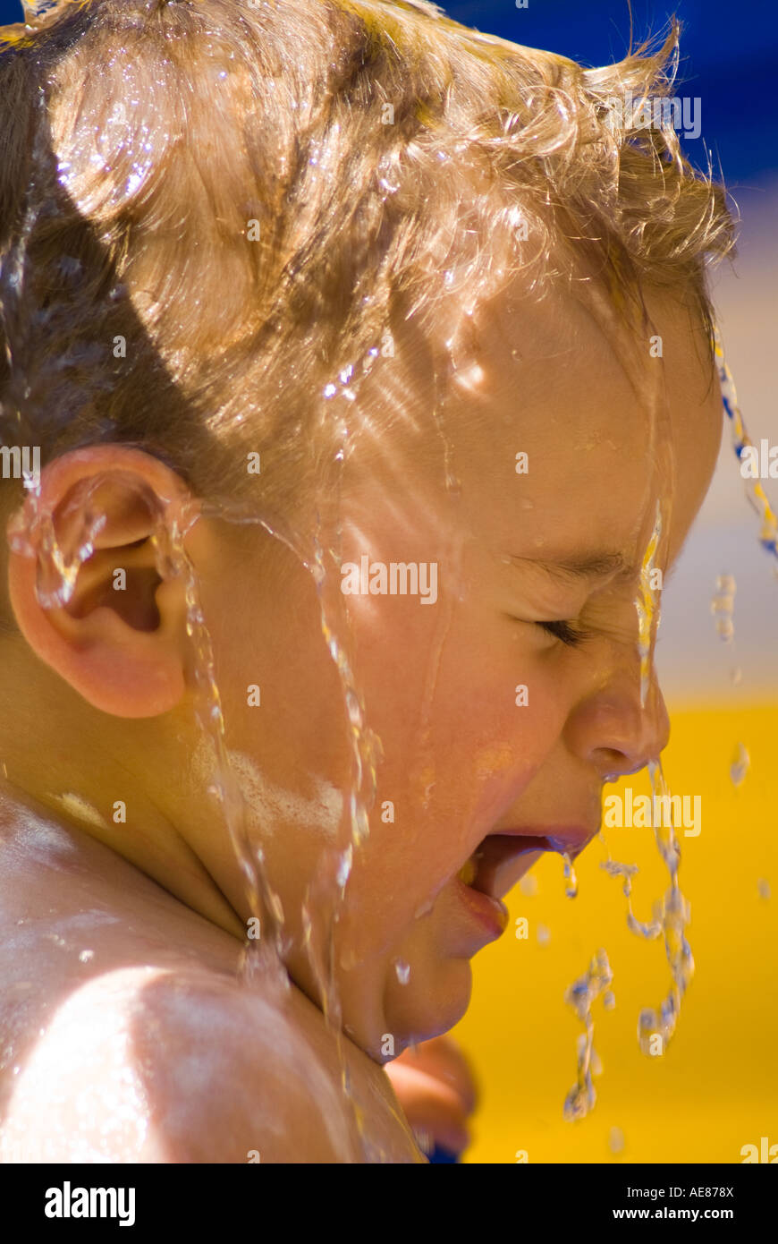 One year old baby playing with water in the swimming pool Stock Photo