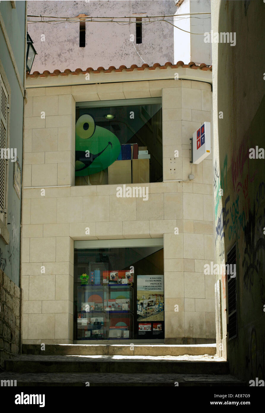 Side street alley looking towards a cartoon frog at window of shop, Cascais, near Lisbon, Portugal. Stock Photo