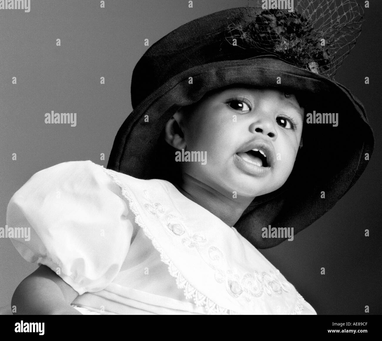 Baby In Black Hat Crown Baby Bonnet Headdress child children Black White African American Girl Age 2-4 Stock Photo
