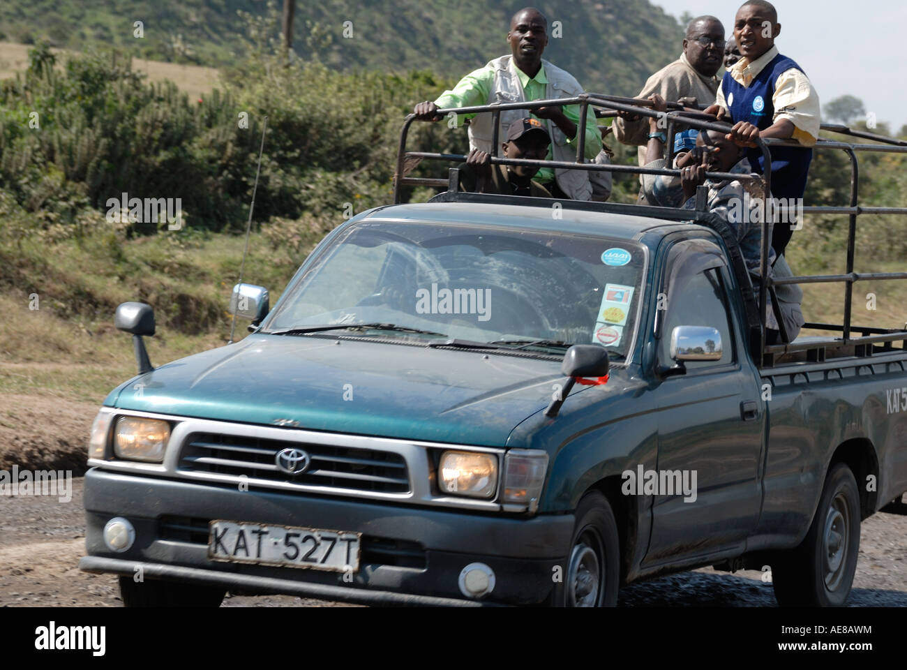 Overloaded Toyota pickup truck carrying several men in the back on the main Nairobi Kisumu road Kenya East Africa Stock Photo