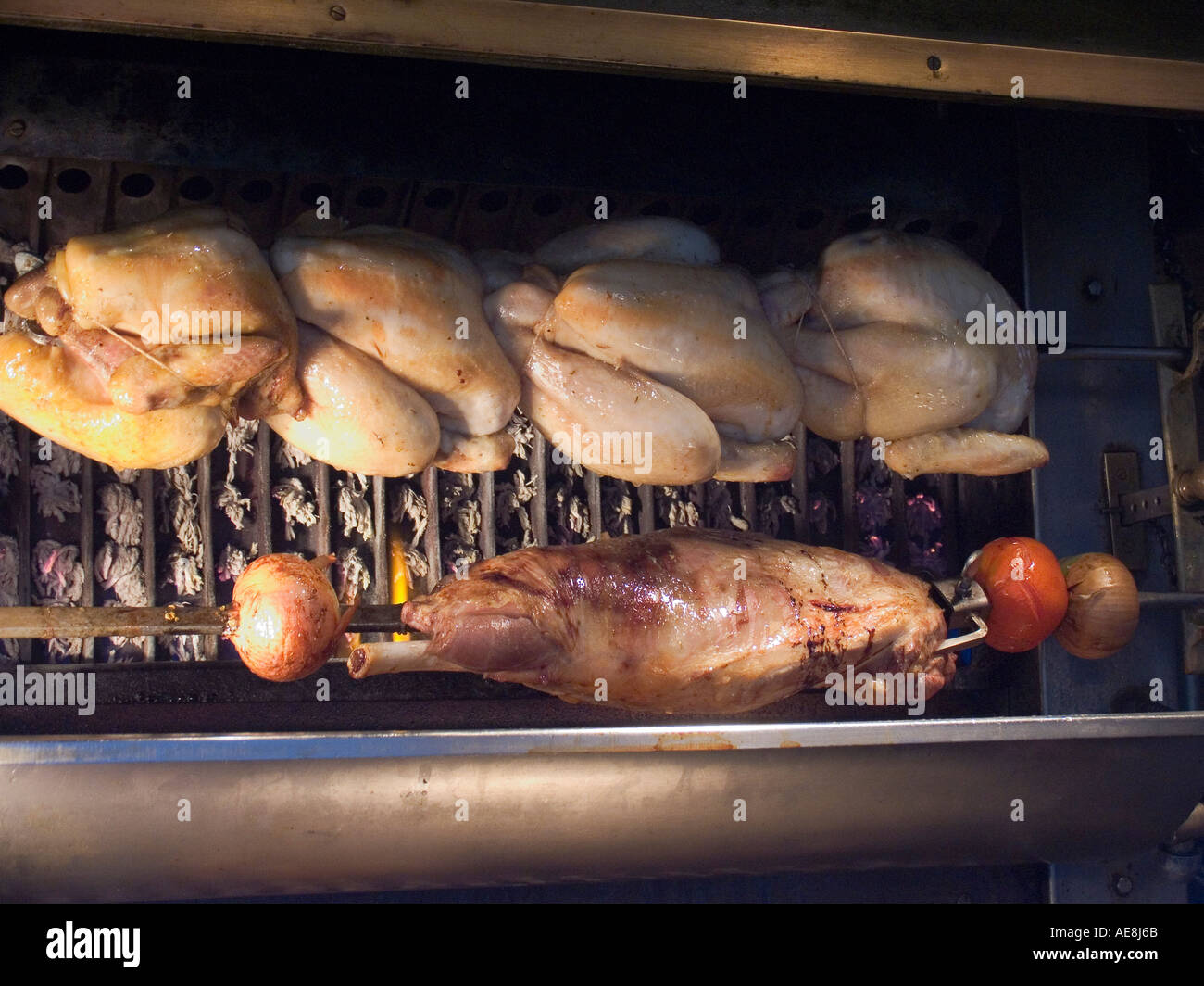 Roasting chicken and lamb in rotisserie at restaurant in the Latin