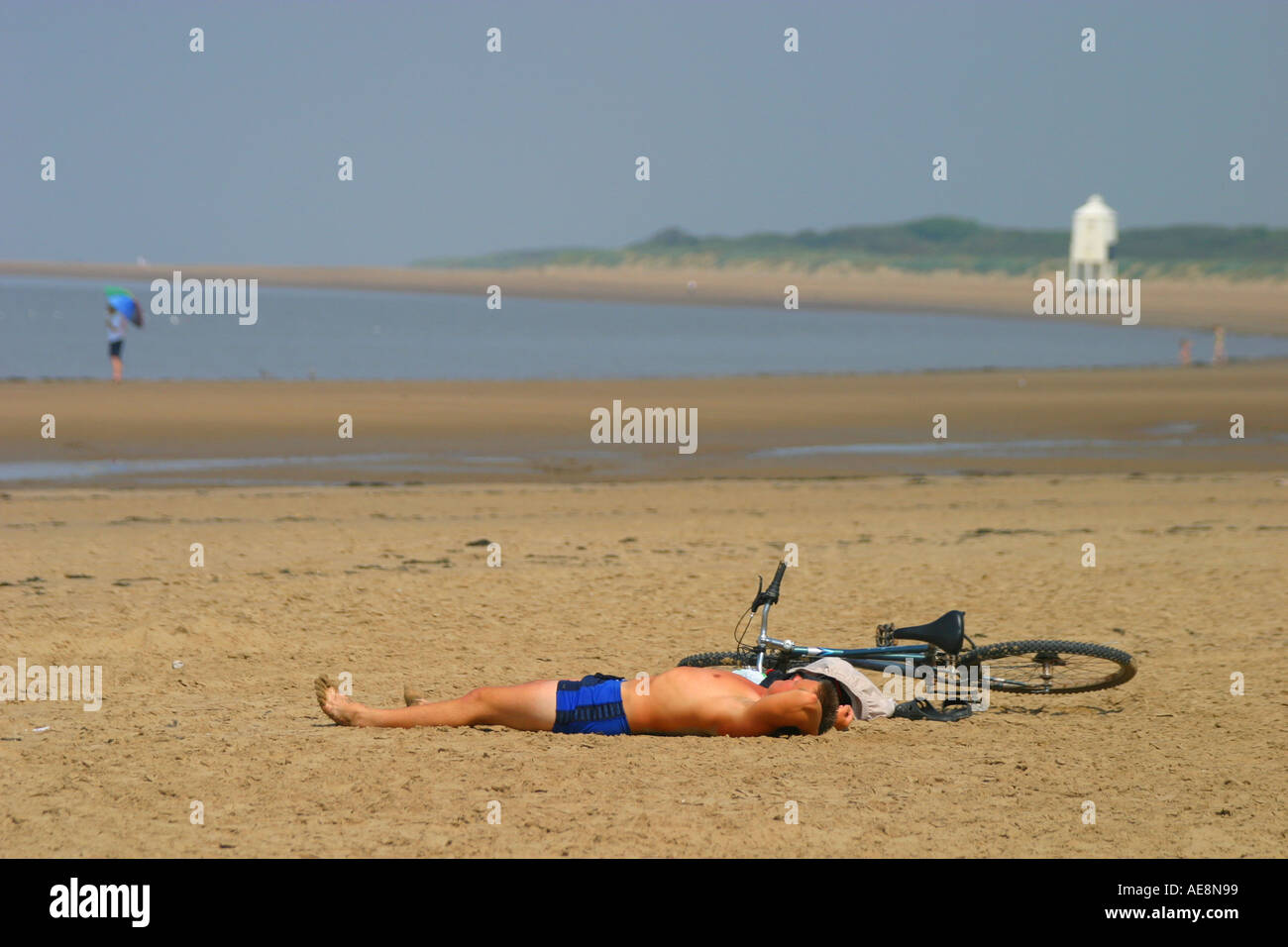 Burnham on Sea beach and lighthouse man and mountain bike sunbathing in