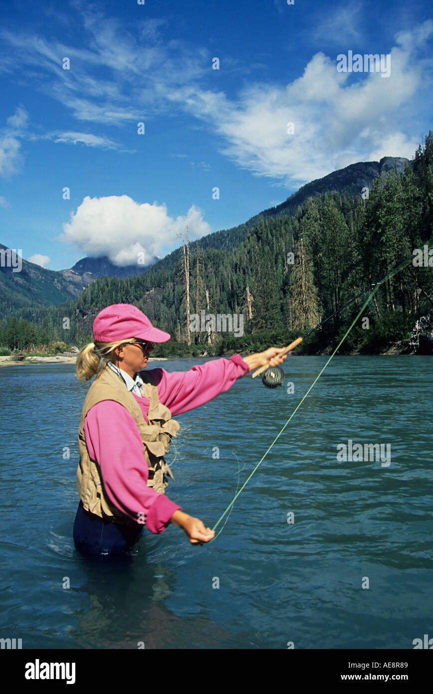 Lady flyfisher casting for salmon Giltoyees river Douglas Channel British Columbia Stock Photo