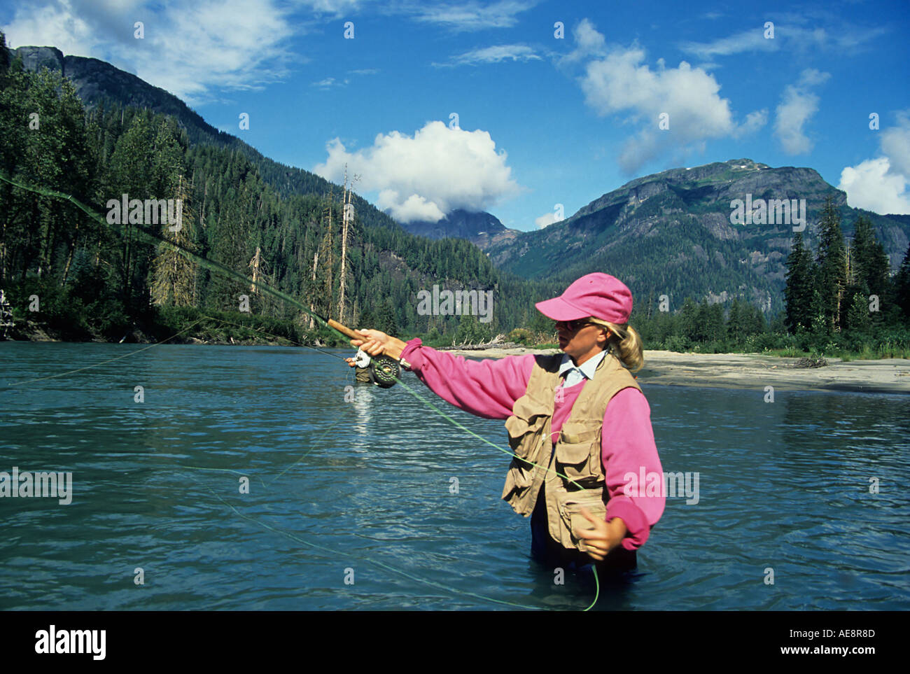 Lady flycaster fishing for salmon Giltoyees river Douglas Channel British Columbia Stock Photo