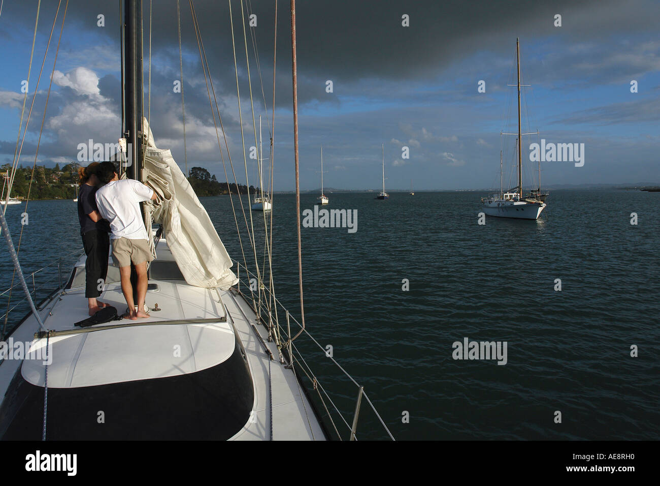 Couple maintaining the sails and rigging of a sailing yacht, Waitemata