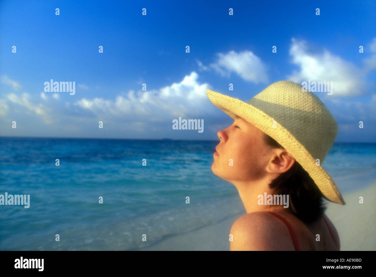 Woman in straw hat on beach Model released image Stock Photo