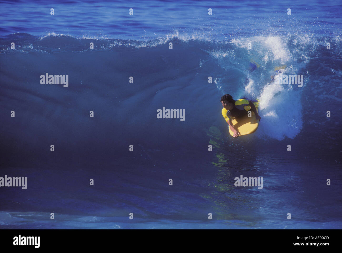 Man riding bodyboard while surfing on large wave in California Model released image Stock Photo