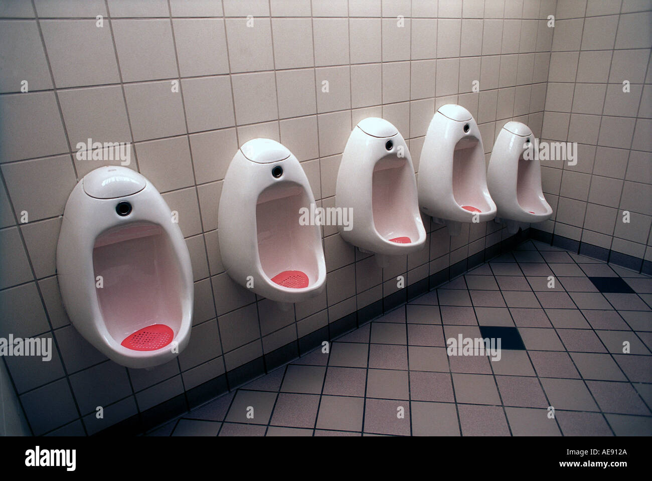 Row of urinals in public restroom Stock Photo