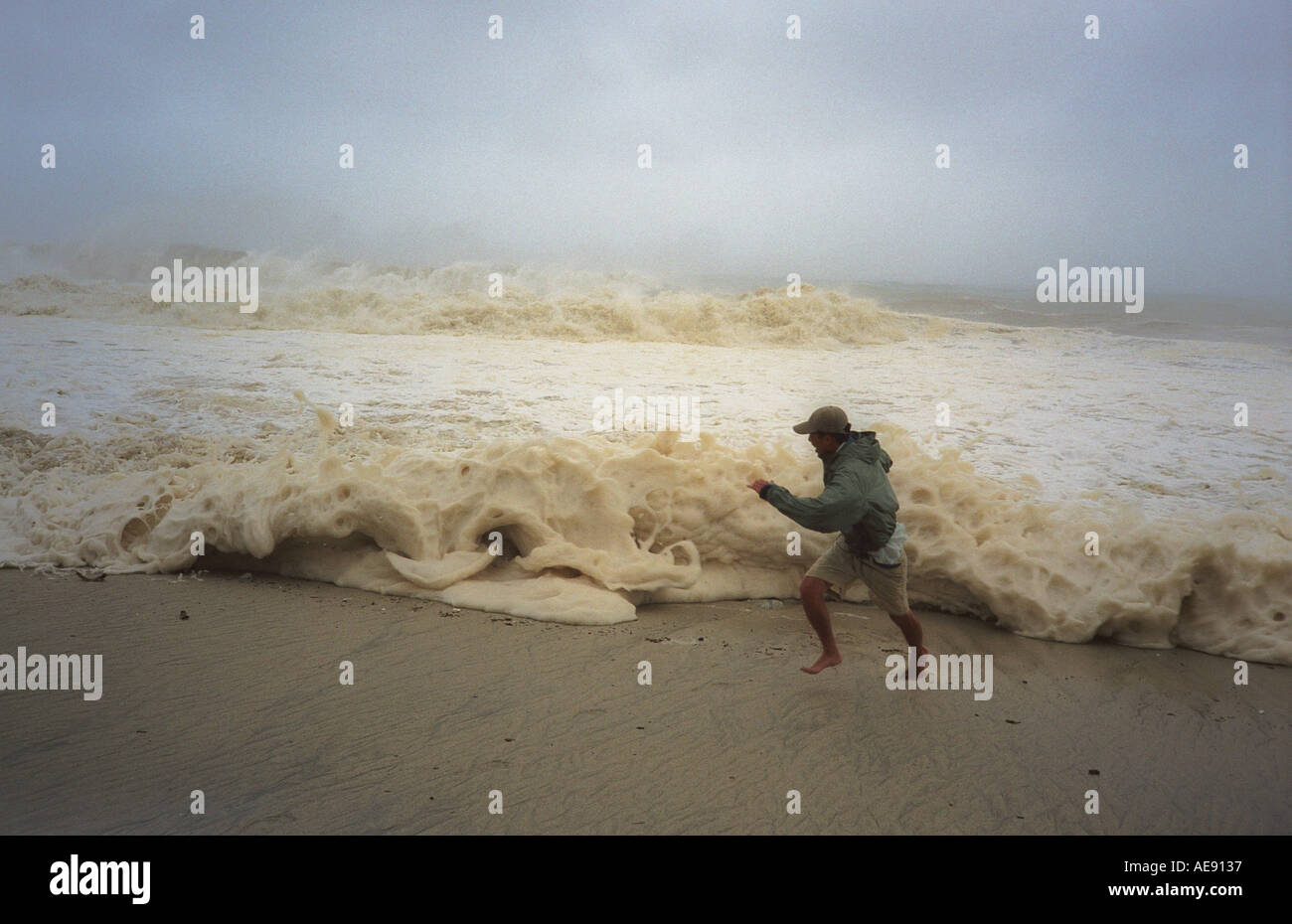 Man running ahead of approaching wave caused by hurricane Ignacio Baja California Mexico Model released image Stock Photo