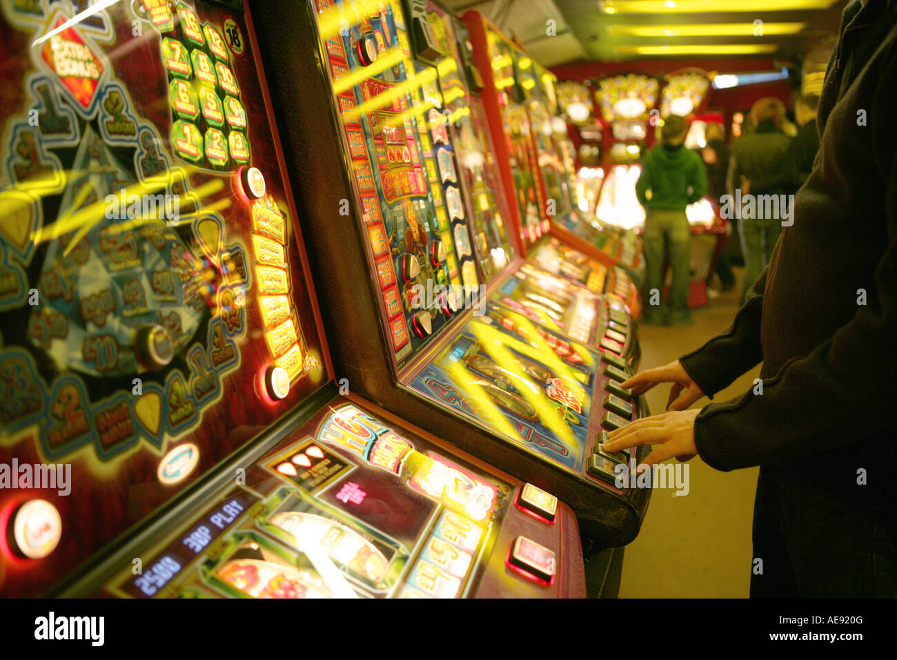 Playing fruit machines in an arcade Stock Photo Alamy