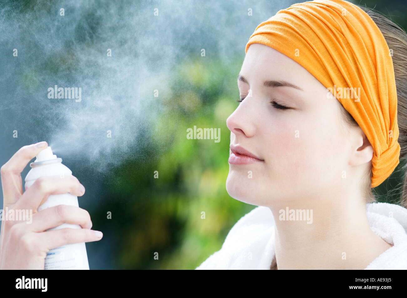 Woman spraying water on her face, Indoors Stock Photo Alamy