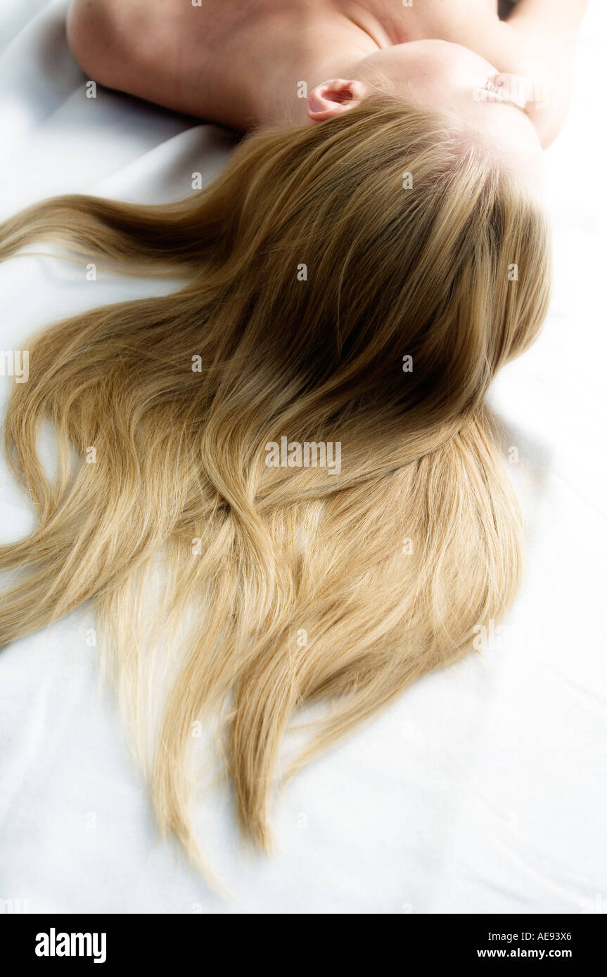 Portrait of a young woman lying, long hair on floor Stock Photo