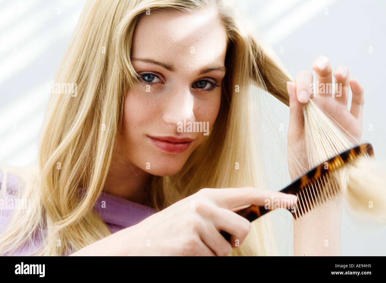 Portrait of a young woman combing her hair Stock Photo Alamy