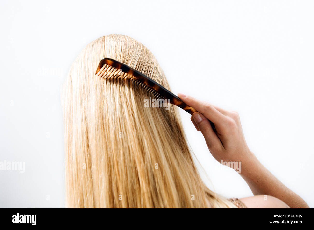 Portrait of a young woman combing her hair, view from the back Stock ...