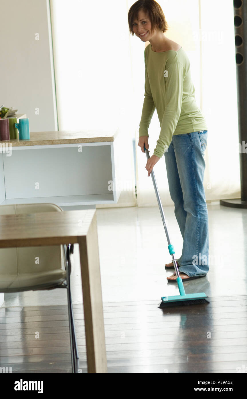 Young woman sweeping floor hi-res stock photography and images - Alamy
