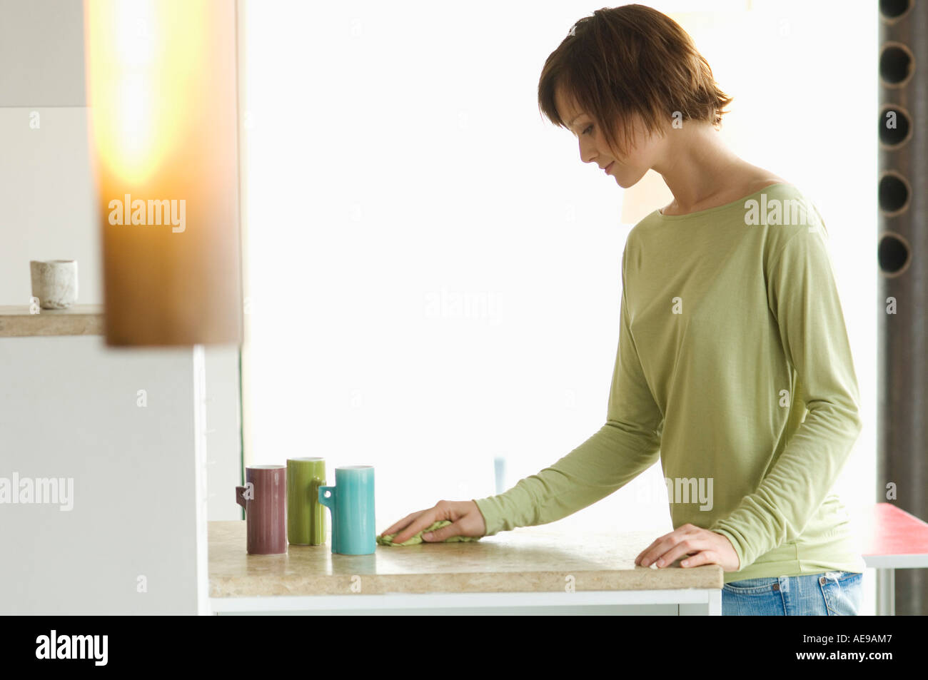 Young woman cleaning kitchen work-top Stock Photo