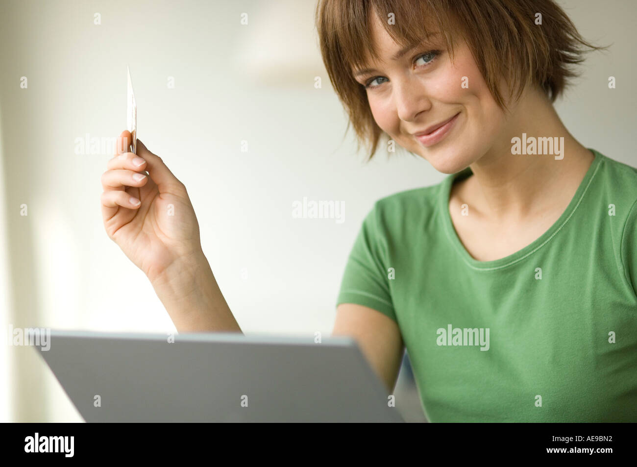 Young woman using laptop computer, smiling for the camera Stock Photo