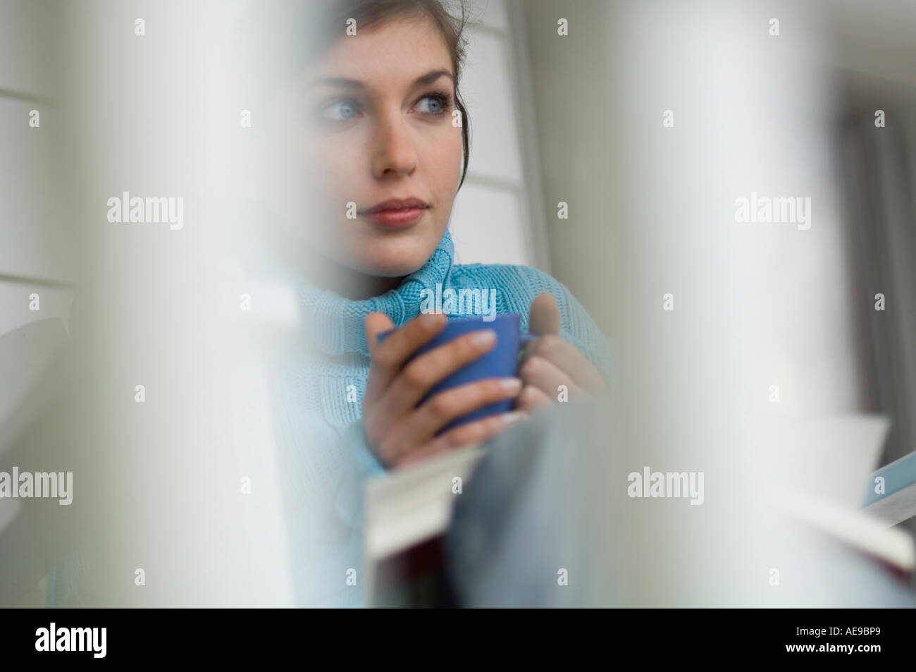 Young thinking woman holding cup Stock Photo