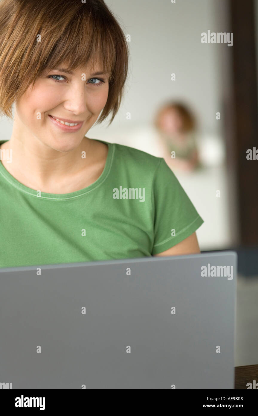 Young woman using laptop computer, smiling for the camera Stock Photo