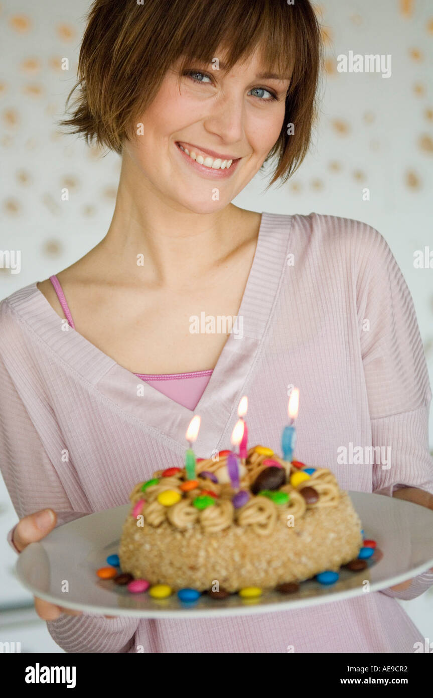 Portrait of a smiling woman holding birthday cake Stock Photo - Alamy