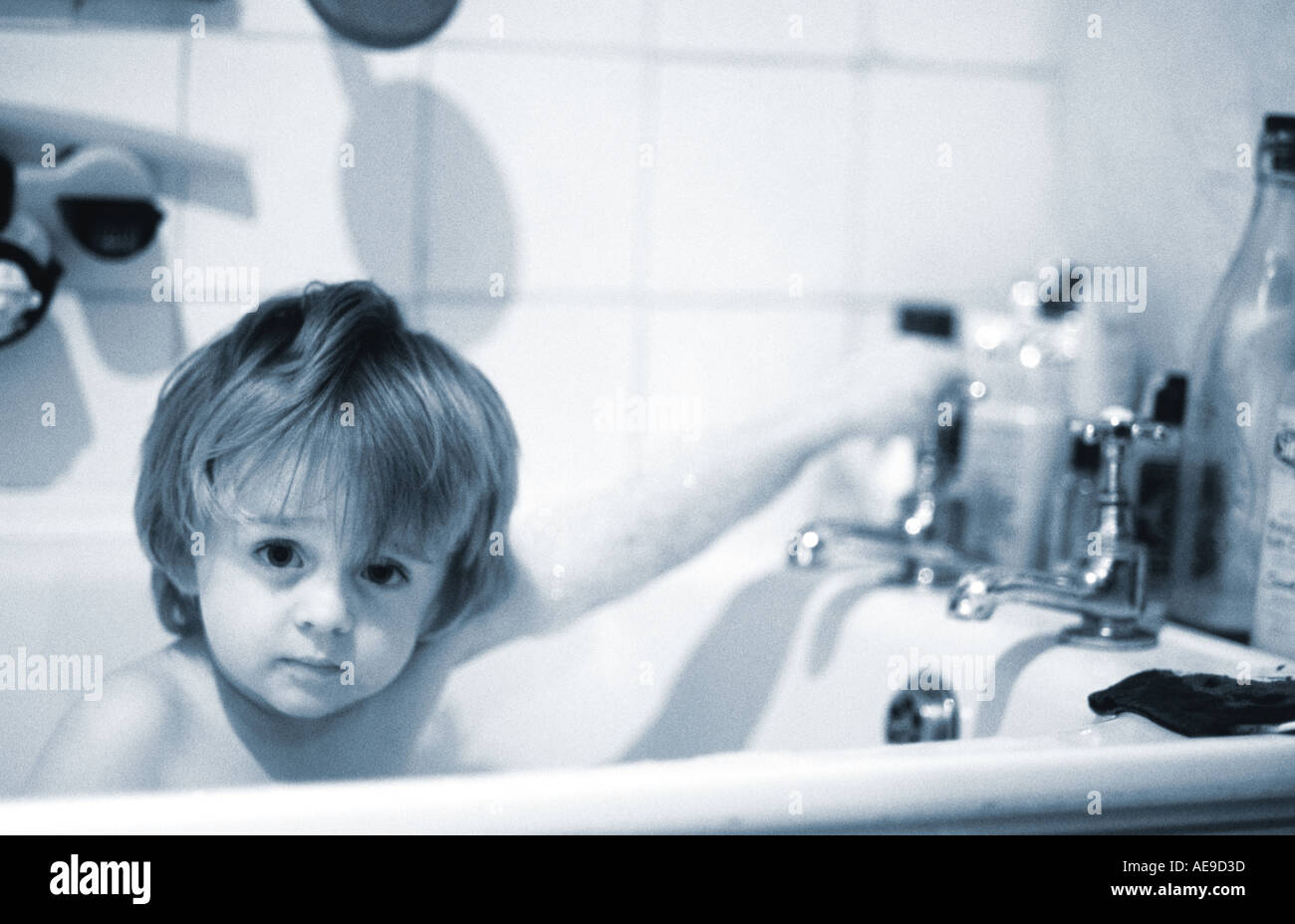 small boy turning of tap in bath Stock Photo Alamy