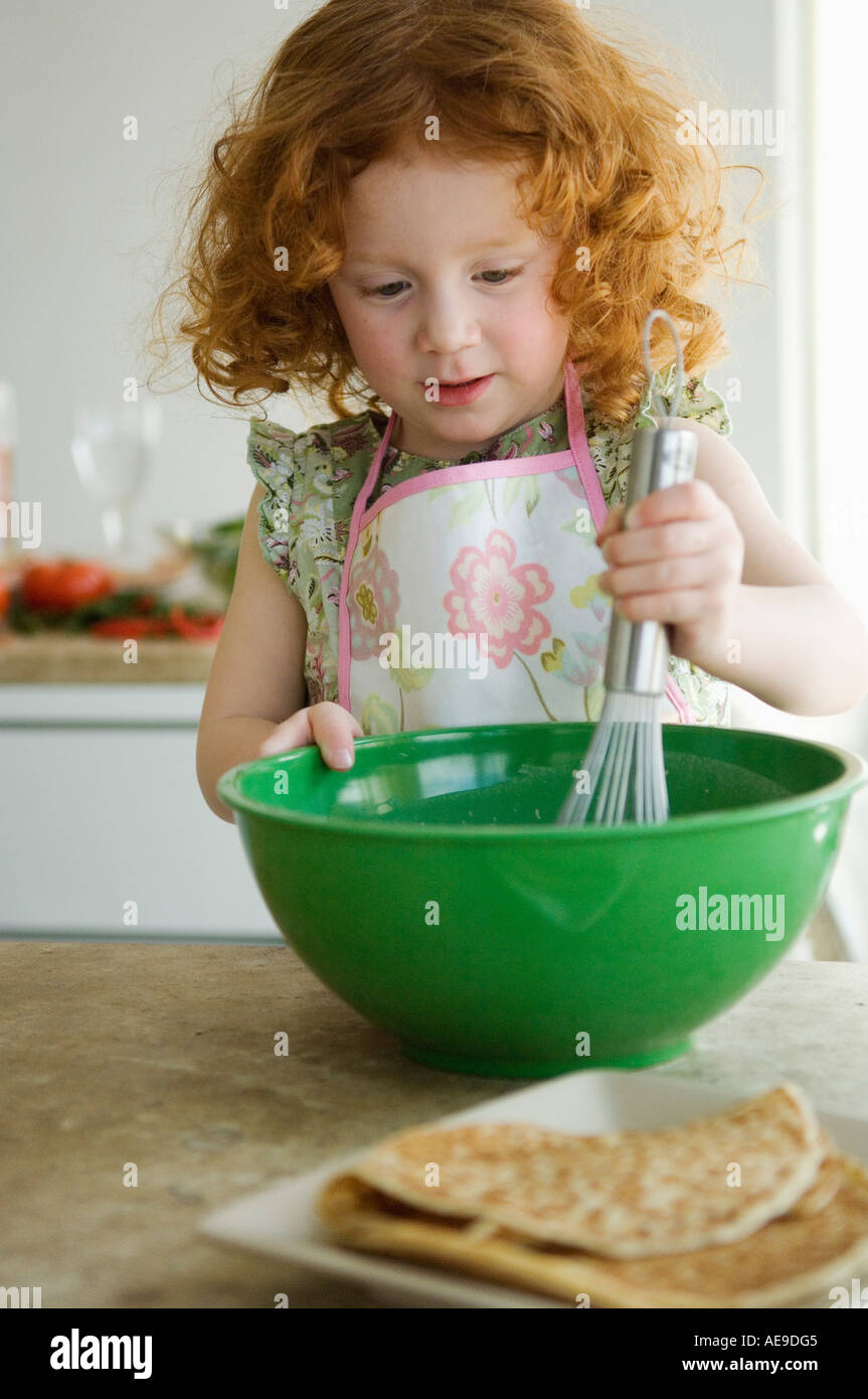 Little Girl Mixing Ingredients In A Bowl With A Whisk Stock Photo Alamy