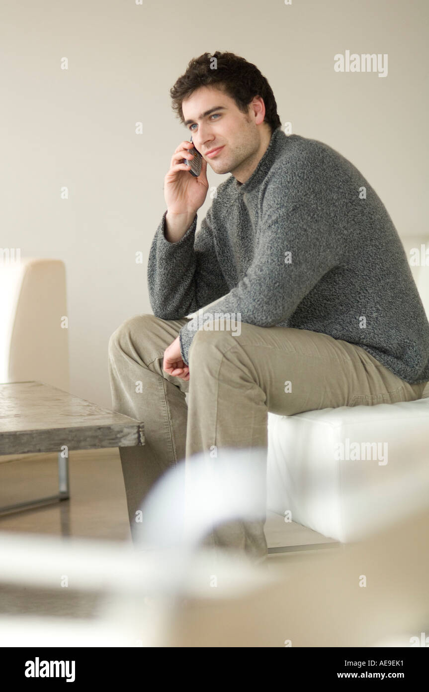Man sitting on a sofa using a mobile phone Stock Photo