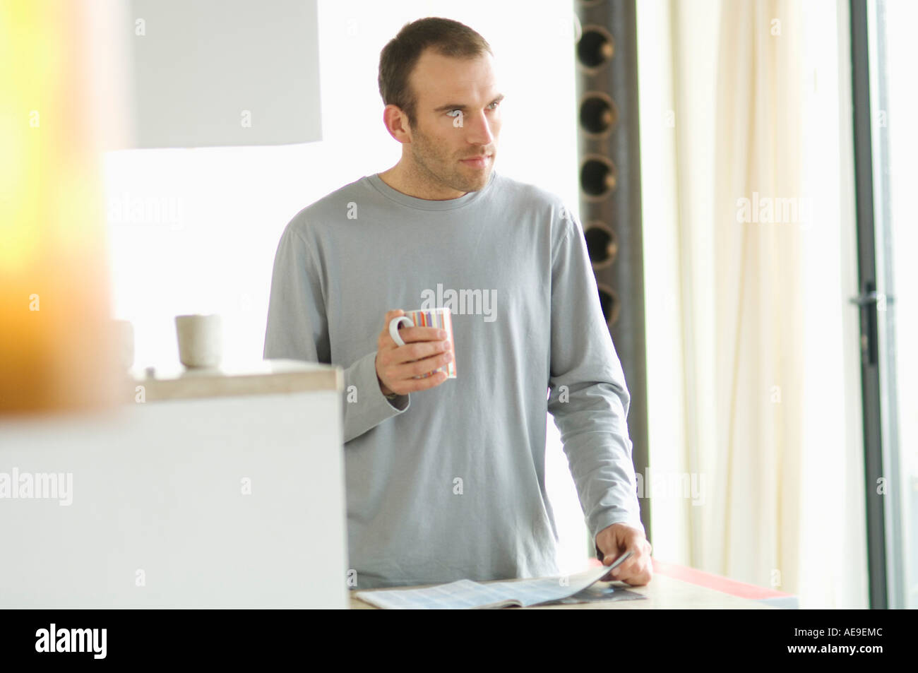 Man standing in the kitchen, holding mug Stock Photo