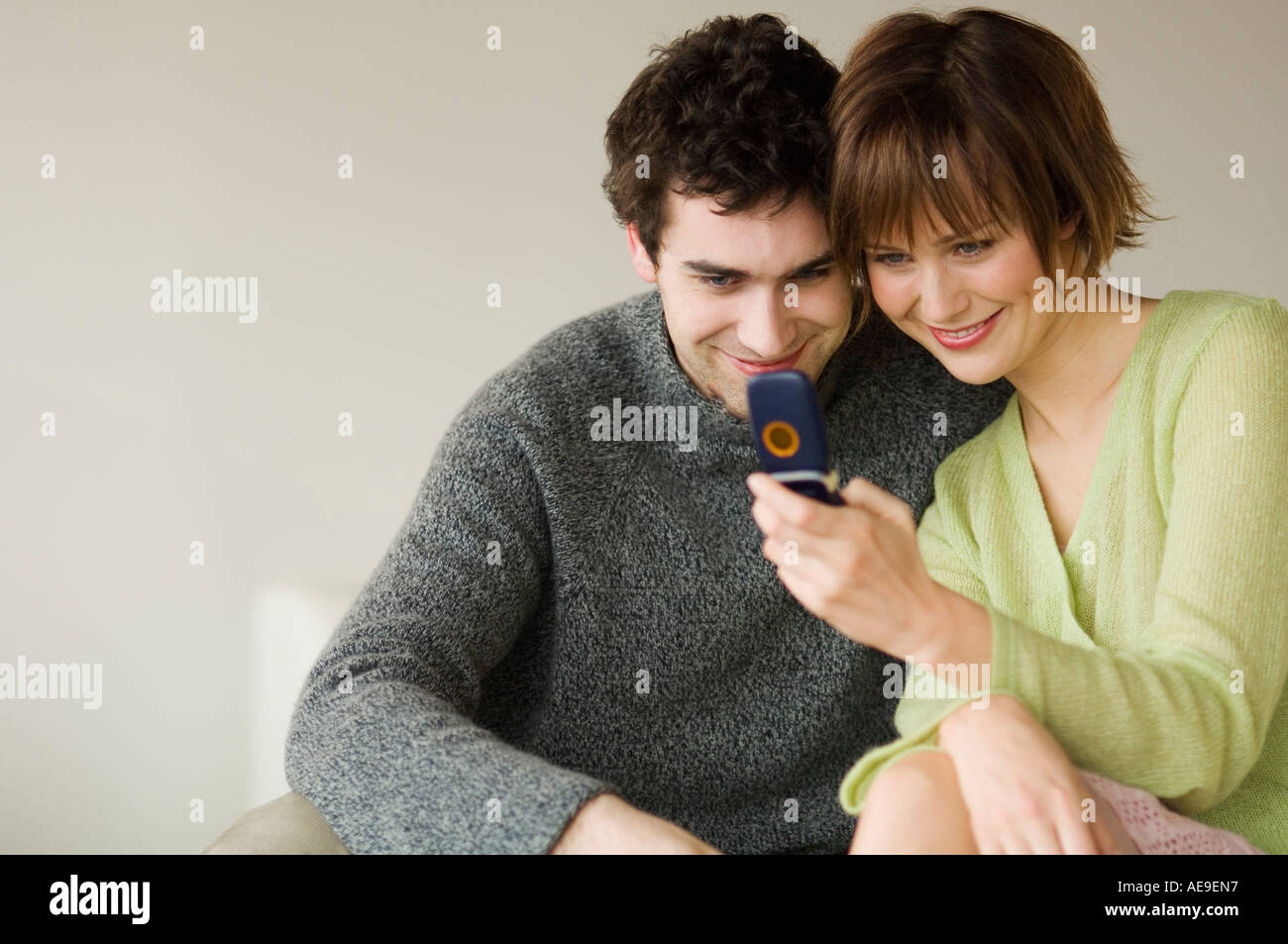 Smiling couple looking at mobile phone Stock Photo