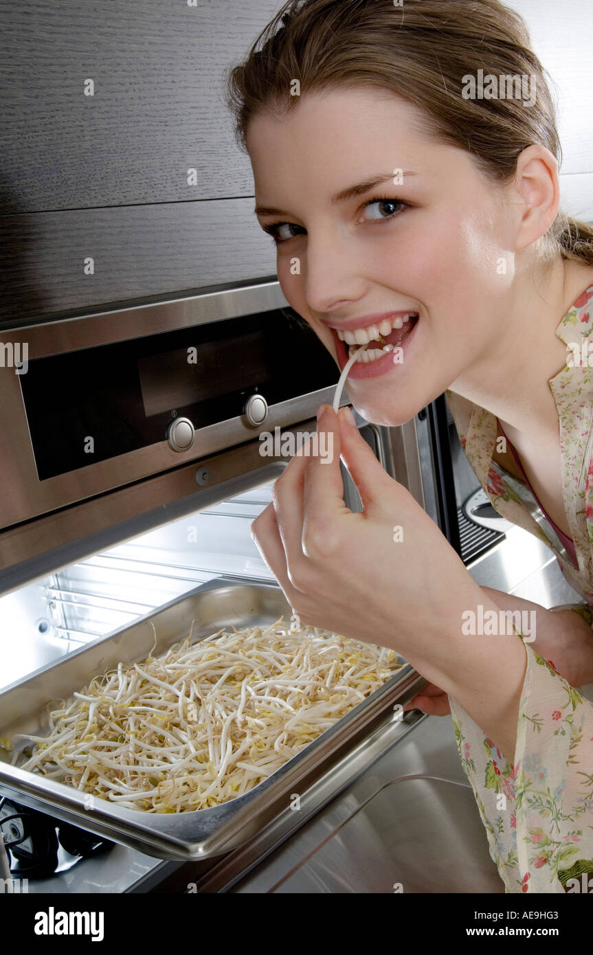 Young woman eating bean sprouts coming out of the oven Stock Photo Alamy