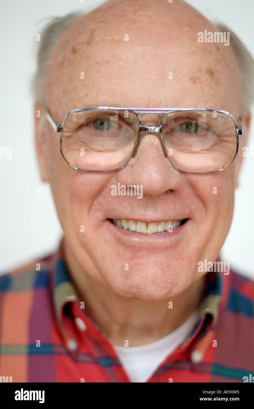 Studio portrait of balding man wearing glasses smiling and looking at camera Stock Photo